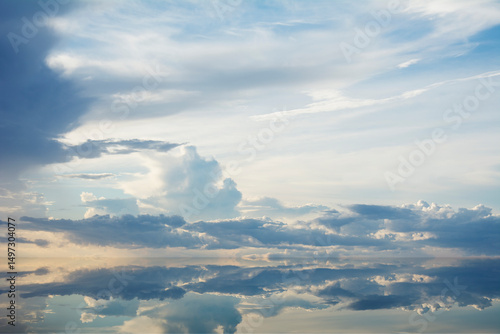 Sunset clouds reflected in calm water surface