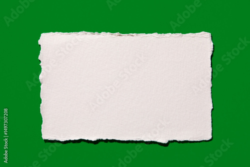 Torn white paper on green background