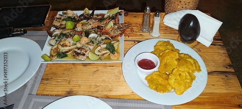 Grilled Seafood Platter with Lobster, Shrimp, Clams and Tostones on Rustic Wooden Table