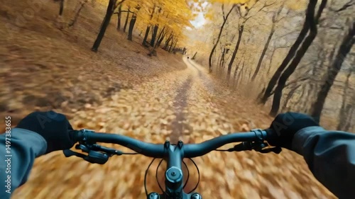 Cyclist riding bicycle on autumn forest trail with fallen leaves and dynamic motion blur capturing vibrant outdoor nature adventure