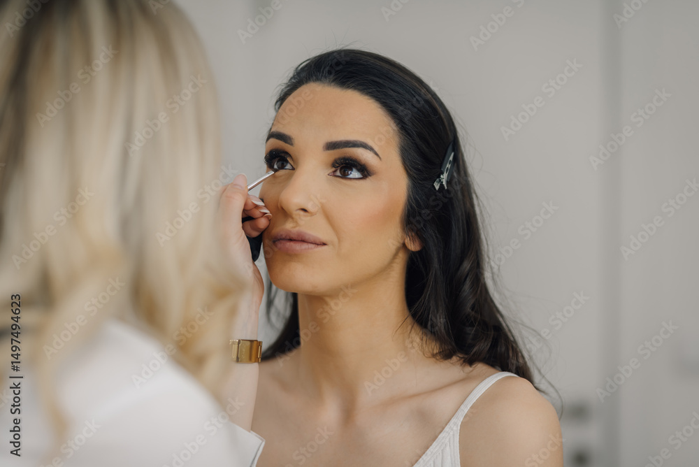 Makeup artist applying eyeliner to young woman's eyelid Makeup artist applying eyeliner to young woman's eyelid