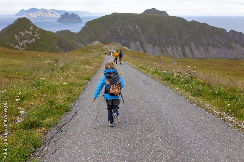Obraz premium Family with kids and dog, hiking in Vaeroya island, the most famous hike Haen, children enjoying hiking on a sunny day