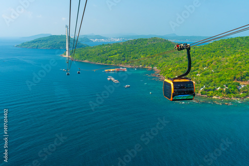 Aerial view of cable car gondola gliding over turquoise sea and green tropical island. Longest Hon Thom cable car ride in the world on Phu Quoc island, Vietnam. Modern tourism technology