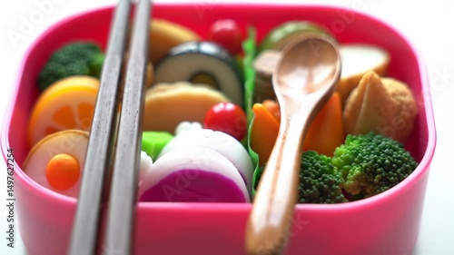 Close Up of Colorful Bento Box with Chopsticks and Spoon Bright Lighting