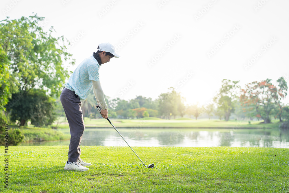 Fototapeta premium Asian amateur golfer is performing a tee off swing, man playing golf in golf course.