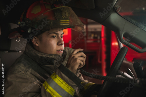 Photography Firefighter driving a truck and talking on the radio to respond to a fire