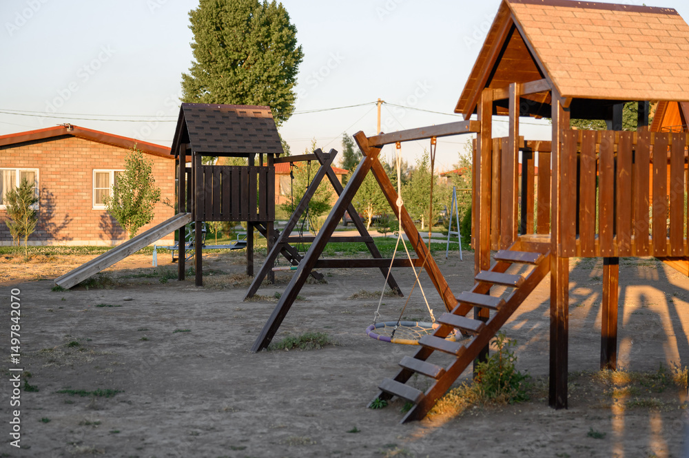 Fototapeta premium Children's outdoor play complex. Children's playground with swings and stairs