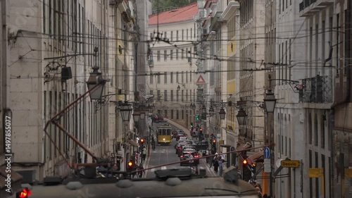 View of yellow city tram (famous scenic no 28) and traffic on Lisbon street, Lisbon, Portugal, Europe