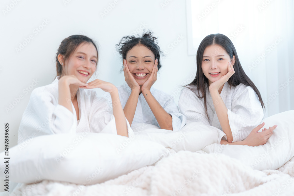 Three smiling women in white bathrobes leaning together, enjoying a relaxing spa day with joy, unity, and friendship. Three smiling women in white bathrobes leaning together, enjoying a relaxing spa day with joy, unity, and friendship.