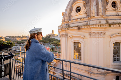 Photography Stylish woman with drink enjoys golden hour on a rooftop terrace in Rome