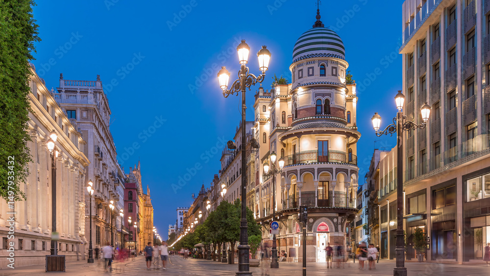 Obraz premium Illuminated Adriatica building on Avenida de la Constitucion at night, Seville, Spain