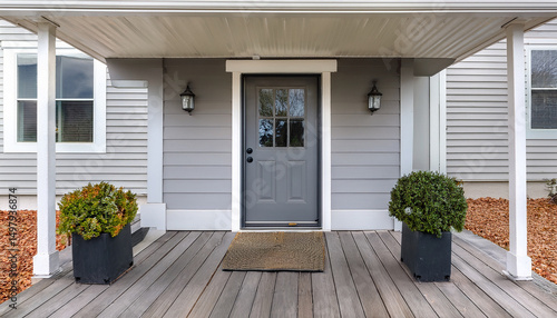a grey modern farmhouse front door with a covered porch wood front door with glass window and grey vinyl and wood siding