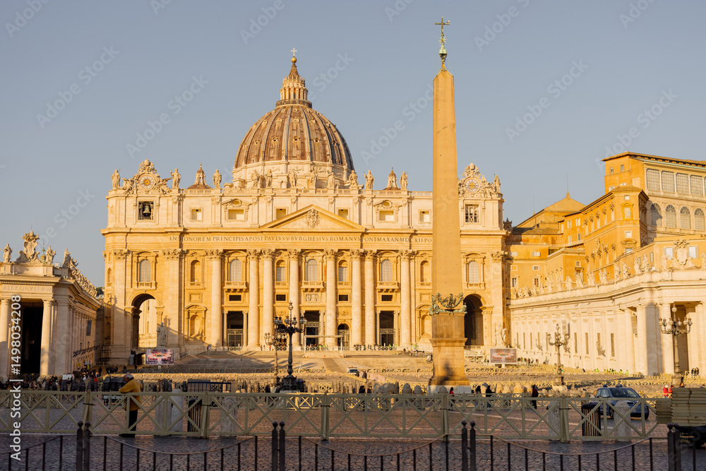Obraz premium St Peters Basilica and the Vatican obelisk glow in the soft golden hour light in Rome. Ideal for editorial content and travel campaigns highlighting iconic European landmarks
