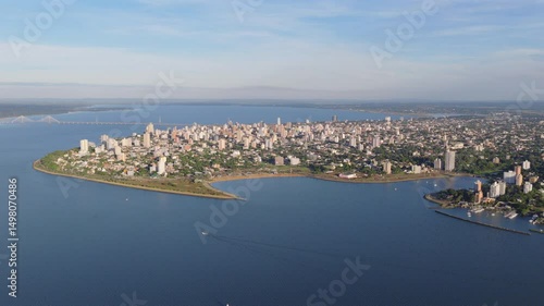 Expansive aerial panorama of Posadas, capital of Misiones, Argentina, with the winding Paraná River and the San Roque González Bridge in the background.
