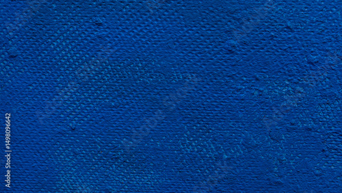 Close-up of a textured wall with deep blue paint, showing subtle brush marks and surface imperfections