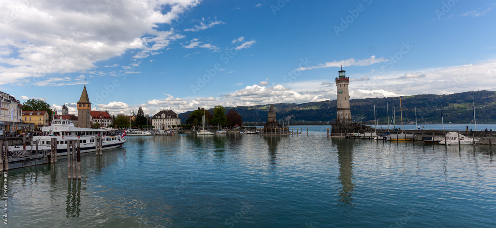 Fototapeta premium Panoramic view of Lindau harbor, featuring the Mangturm tower and the iconic lighthouse and lion statue