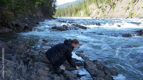 tired hiker finds a small lagoon with fresh water next to a waterfall and wash the face with fresh spring water - 4K Video
