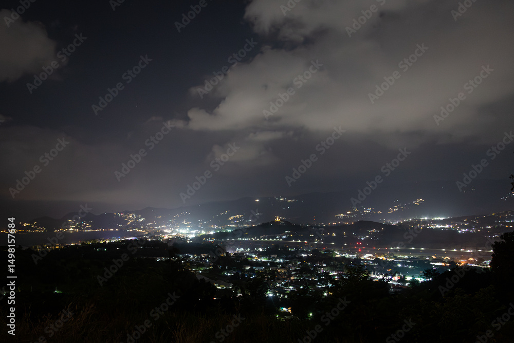 Obraz premium Ko Samui at night, Image shows sunset over the small island from the top of a mountain overlooking the airport, runway and nearby town 