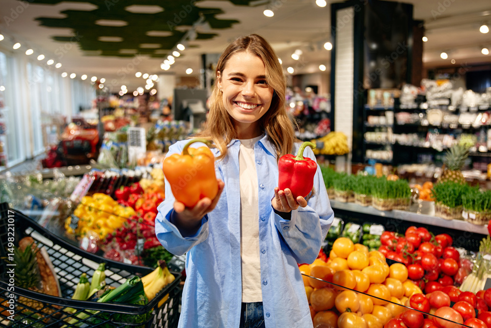 Happy woman choosing bell peppers at grocery store Happy woman choosing bell peppers at grocery store