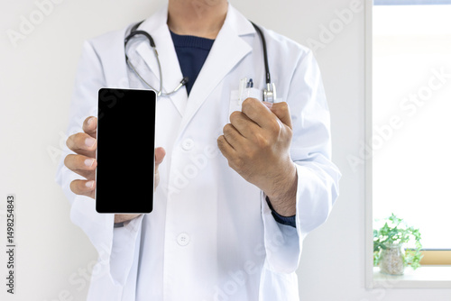 スマートフォンの画面を見せる医者のイメージ（日本人、男性、顔無し、30代）