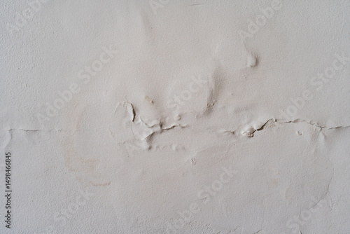 Pared blanca con humedad, grietas y desprendimiento de pintura