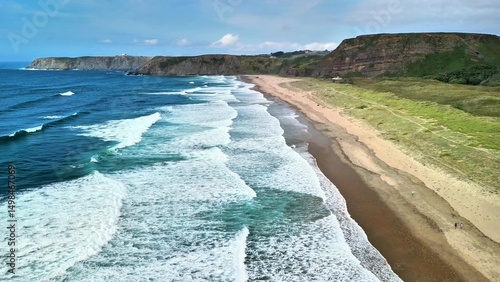 Experience breathtaking coastal views with waves crashing on a sandy beach, a mesmerizing sight