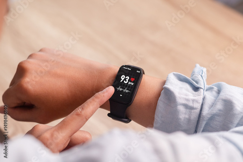 A woman measures her heart rate using her smart watch