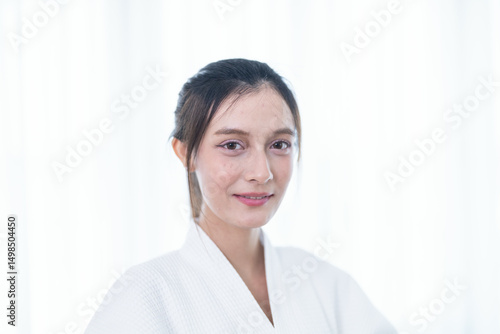 Portrait of a young Asian woman in a white bathrobe posing confidently with soft natural lighting. Free Download Portrait of a young Asian woman in a white bathrobe posing confidently with soft natural lighting. - GFXLoad