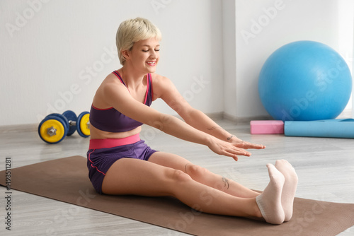 Smiling young woman stretch...
