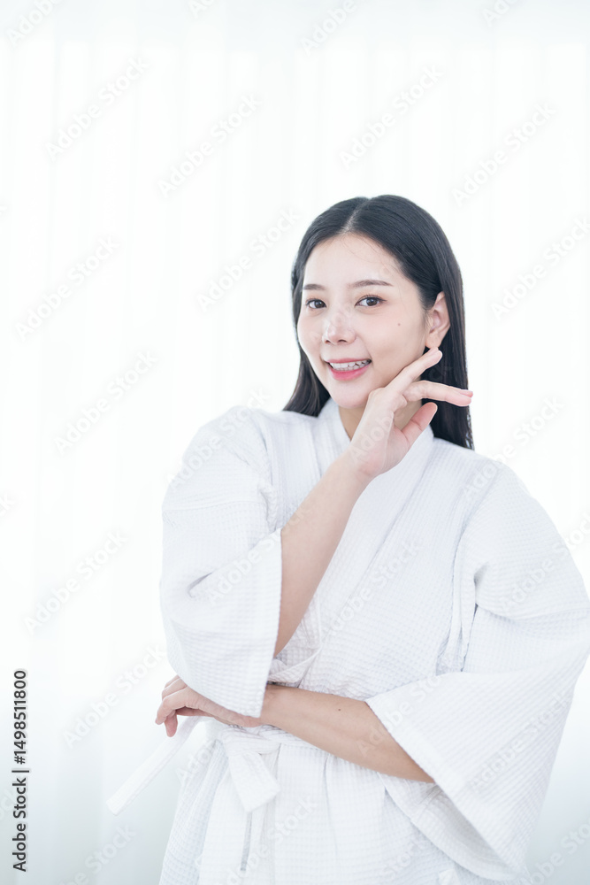 Young woman in a white bathrobe standing confidently, embracing natural beauty and self-care in a serene, minimalist setting. Young woman in a white bathrobe standing confidently, embracing natural beauty and self-care in a serene, minimalist setting.