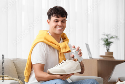 Young man cleaning sneaker ...