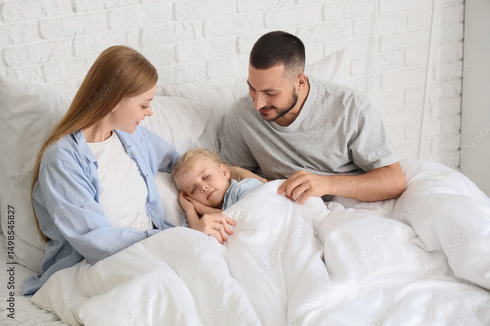 Obraz premium Cute little girl sleeping with her parents under blanket in bedroom