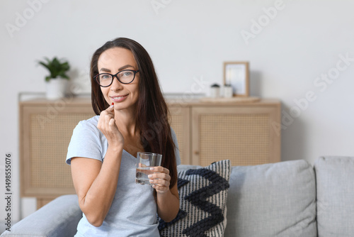 Beautiful woman taking pill...