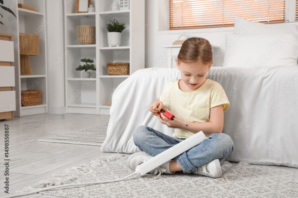 Cute little girl playing with screwdriver and extension cord in bedroom. Child at risk Cute little girl playing with screwdriver and extension cord in bedroom. Child at risk