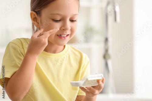 Cute little girl putting co...
