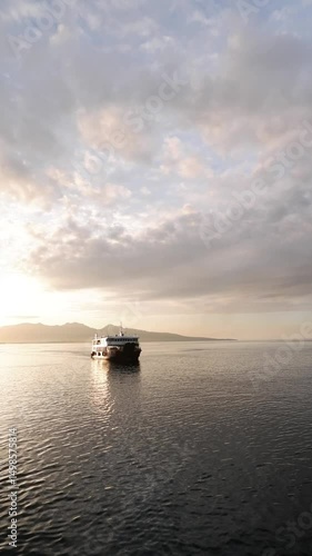 Serene Sunset Seascape with Distant Ferry and Mountain Silhouettes