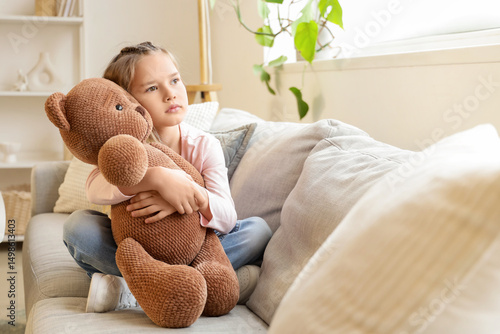 Sad little girl hugging toy...