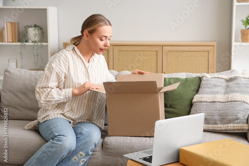 Young woman opening parcel ...