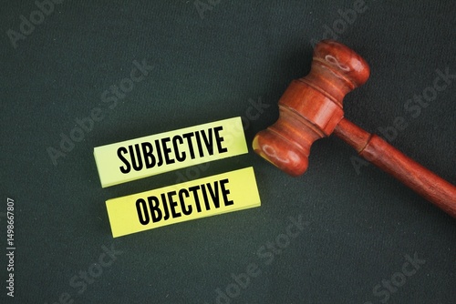 Photos Judge's gavel and paper with the words subjective and objective.