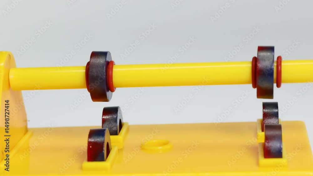 Rotating Magnets on Yellow Stand Close-Up Rotating Magnets on Yellow Stand Close-Up