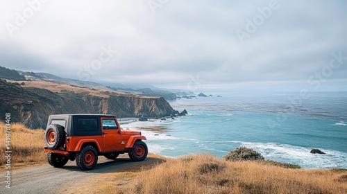 orange off-road vehicle parked on a coastal dirt road overlooking the ocean with rocky cliffs and grassy hills under a cloudy sky