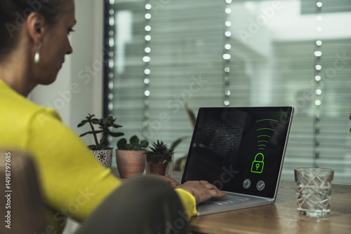 Woman accessing home automation security system on laptop