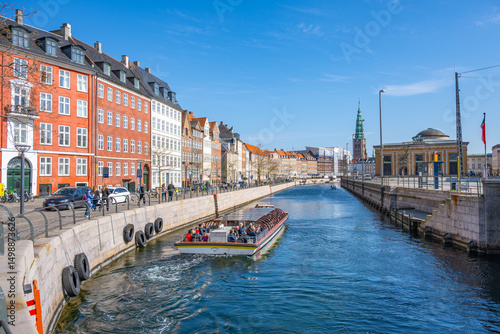 Canvas Print Tourists enjoy a sunny boat ride along Frederiksholms Kanal, surrounded by historic buildings and vibrant architecture in the heart of Copenhagen, Denmark