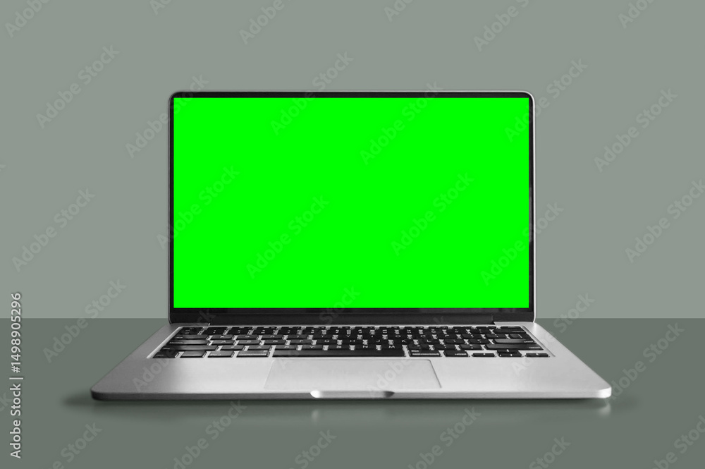Laptop computer with a green screen sitting on top of a table. Laptop computer with a green screen sitting on top of a table.