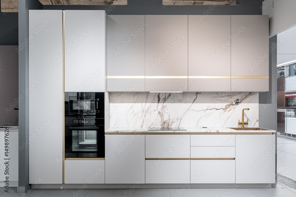 design of large built-in kitchen is white with gold elements, marble countertop, golden faucet and sink. built-in kitchen appliances. upper and lower cabinets, drawers and lots of shelves. design of large built-in kitchen is white with gold elements, marble countertop, golden faucet and sink. built-in kitchen appliances. upper and lower cabinets, drawers and lots of shelves.