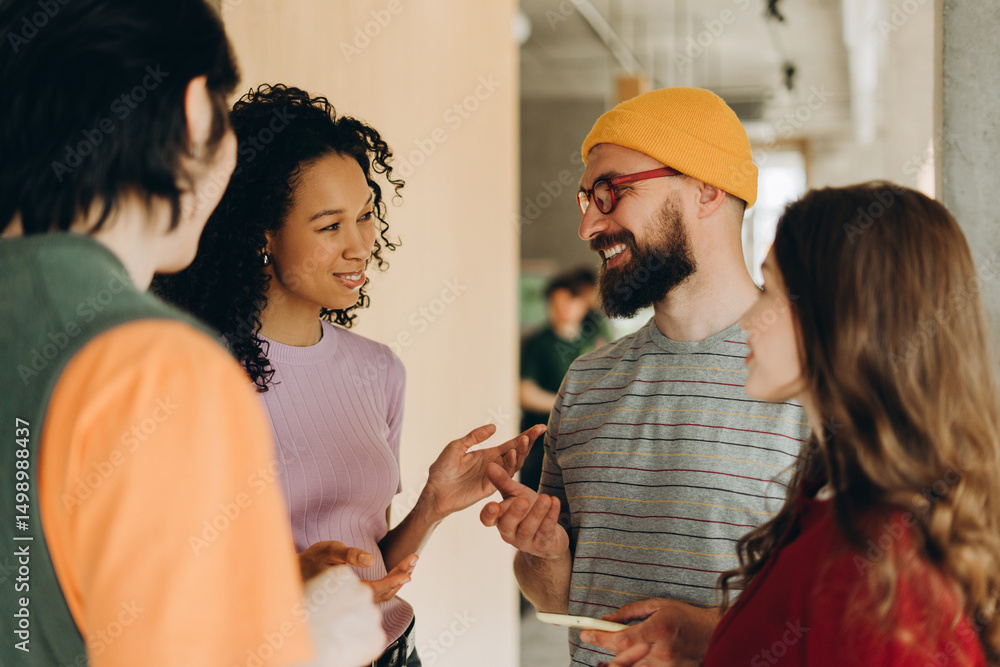 Fototapeta premium Group of young professionals engaging in collaborative discussion in modern office