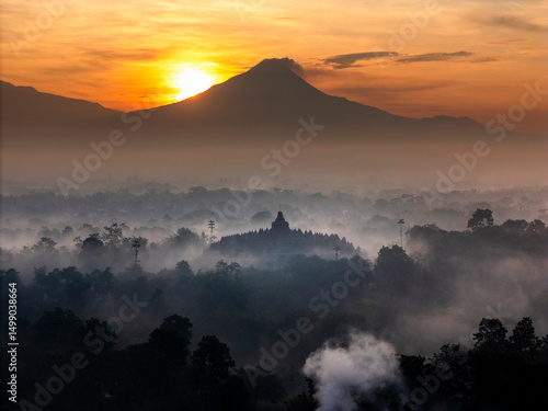 Misty Borobudur temple in the morning with the Merapi, Merbabu and Arjuno mountain in the surroundings. Borodubur is the biggest Buddhist temple in the world that was one of 7 wonders of the worlds.