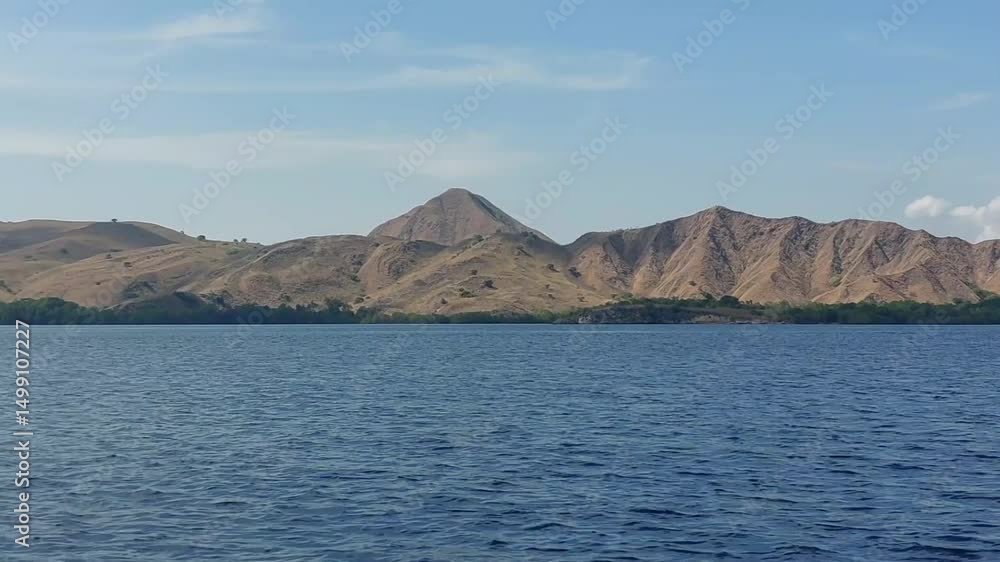 beautiful view of the vast blue ocean with brown and dry hills in the waters of Labuan Bajo
