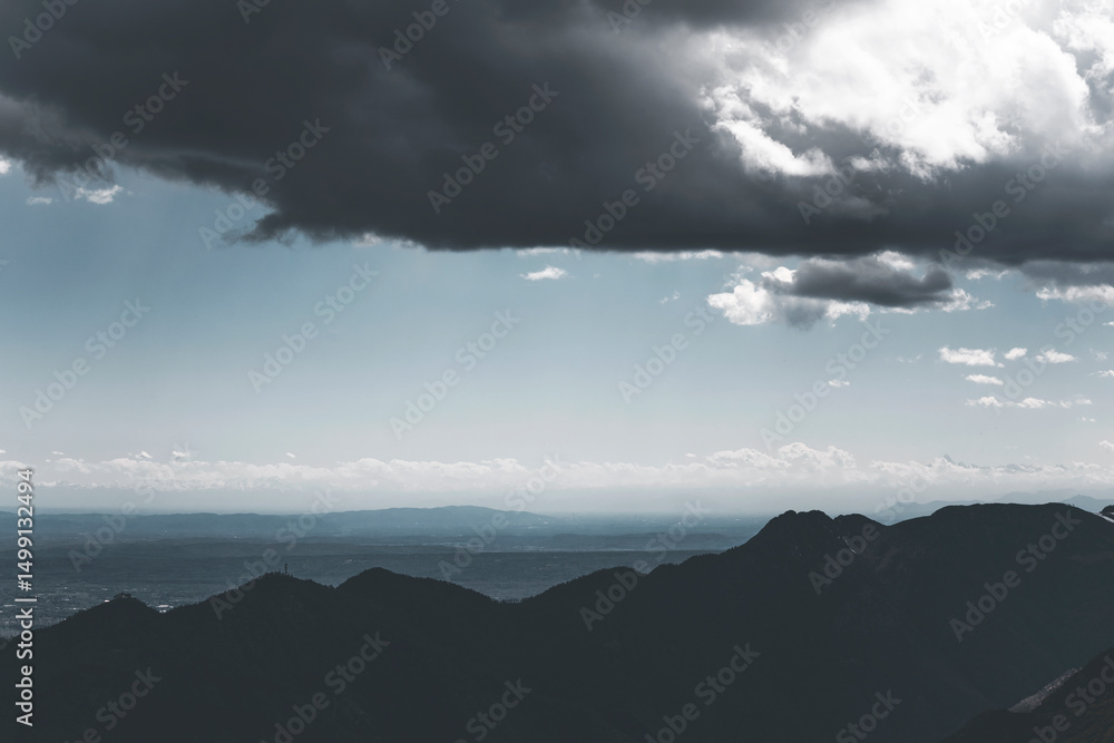 Fototapeta premium dramatic mountain landscape in a very cloudy day, with a blue sky and pastel background
