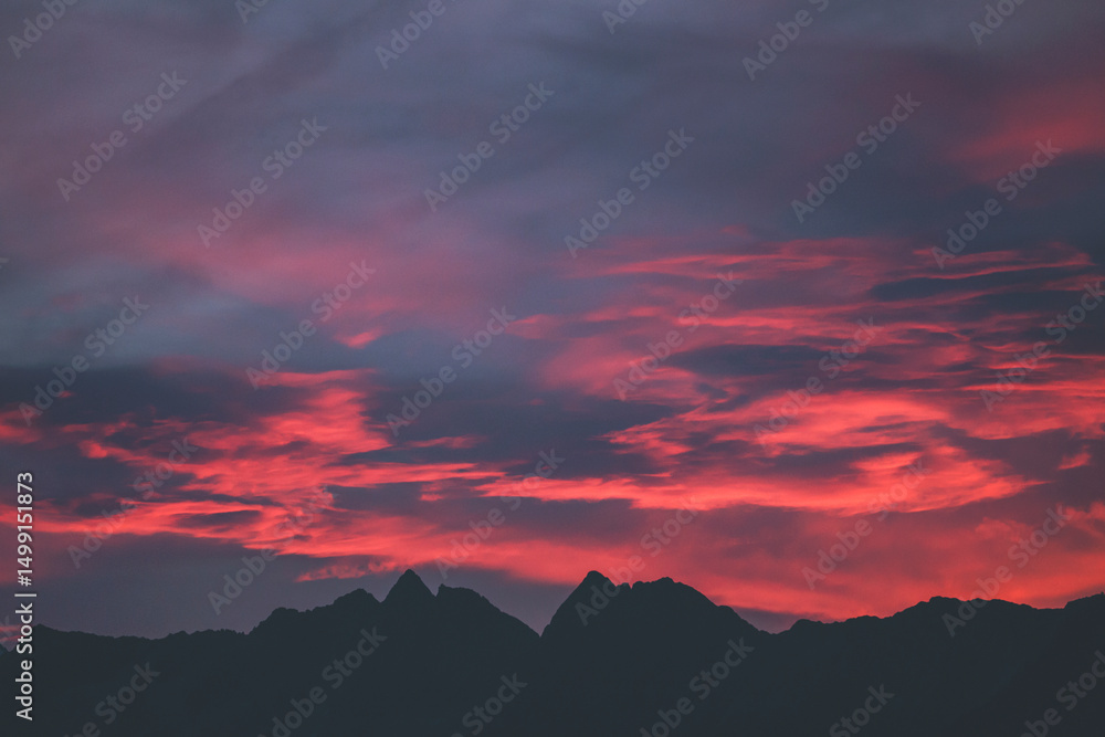 Fototapeta premium stunning and colorful sunrise over the mountains with peaks silhouettes